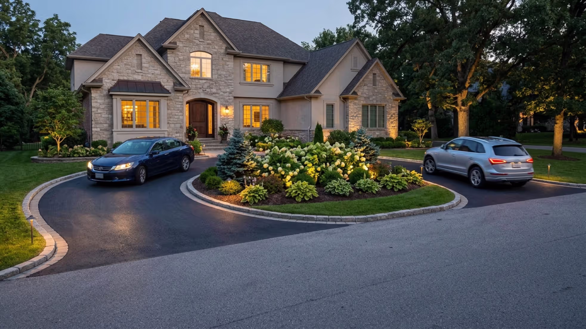 completed half circle driveway with illuminated center island at dusk