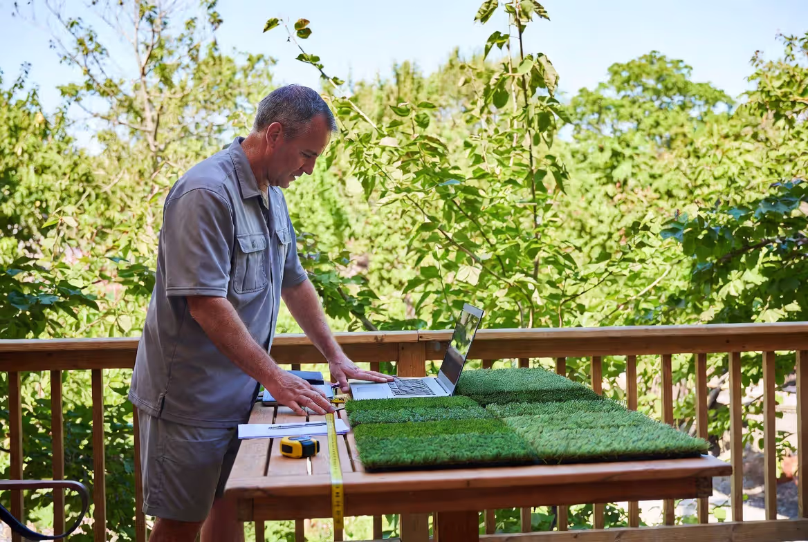 homeowner comparing artificial grass samples before purchase